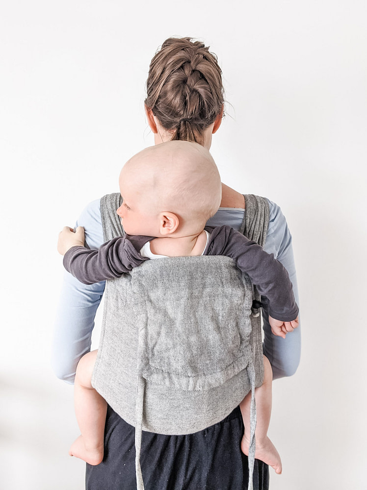 Mom wearing baby on her back in a Girasol Mywrapsol wrap conversion meh dai baby carrier Mom wearing baby on her back in a Girasol Mywrapsol wrap conversion meh dai baby carrier