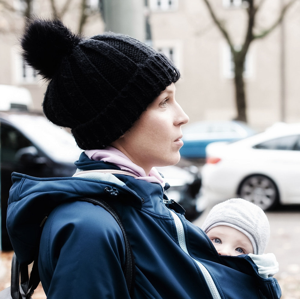 Babywearing mom carrying her baby under a babywearing jacket Babywearing mom carrying her baby under a babywearing jacket